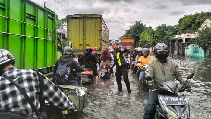 Polisi mengatur lalu lintas saat banjir rendam Pasuruan