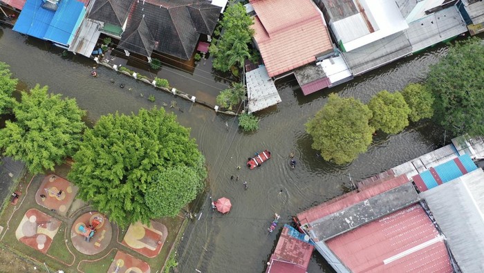 Sejumlah warga berjalan melintasi banjir di Perumahan Bengkuring, Samarinda Utara, Samarinda, Kalimantan Timur, Kamis (30/1/2025). Menurut data Badan Penanggulangan Bencana Daerah (BPBD) Kota Samarinda, banjir di kawasan Samarinda Utara pada hari ketiga berdampak pada 1.235 keluarga yang mencakup 4.414 jiwa dari sebelumnya sebanyak 833 keluarga dengan total 2.677 jiwa. ANTARA FOTO/M Risyal Hidayat/rwa.