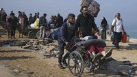 Para pria wanita dan anak-anak yang mengungsi berjalan kaki sambil membawa barang-barang mereka. (AP Photo/Abdel Kareem Hana)