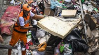 Sejumlah petugas Penanganan Prasarana dan Sarana Umum (PPSU) mengangkut tumpukan sampah yang terbawa banjir di kawasan Jalan Kapuk Bongkaran, Cengkareng, Jakarta, Kamis (30/1/2025).   