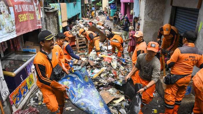 Sejumlah petugas Penanganan Prasarana dan Sarana Umum (PPSU) mengangkut tumpukan sampah yang terbawa banjir di kawasan Jalan Kapuk Bongkaran, Cengkareng, Jakarta, Kamis (30/1/2025). Sebanyak 25 personel PPSU Kelurahan Kapuk dikerahkan untuk mengangkut sekitar dua ton sampah yang terbawa banjir di kawasan permukiman dari empat RT tersebut. ANTARA FOTO/Sulthony Hasanuddin/nym.