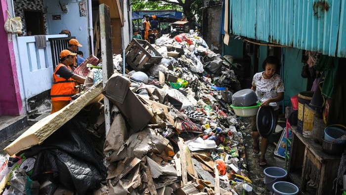 Sejumlah petugas Penanganan Prasarana dan Sarana Umum (PPSU) mengangkut tumpukan sampah yang terbawa banjir di kawasan Jalan Kapuk Bongkaran, Cengkareng, Jakarta, Kamis (30/1/2025). Sebanyak 25 personel PPSU Kelurahan Kapuk dikerahkan untuk mengangkut sekitar dua ton sampah yang terbawa banjir di kawasan permukiman dari empat RT tersebut. ANTARA FOTO/Sulthony Hasanuddin/nym.