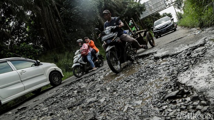 Pengendara melintas di Jalan Raya Serpong-Gunung Sindur, Bogor, Jumat (31/1/2025). Kondisi jalanan rusak dan berlubang.