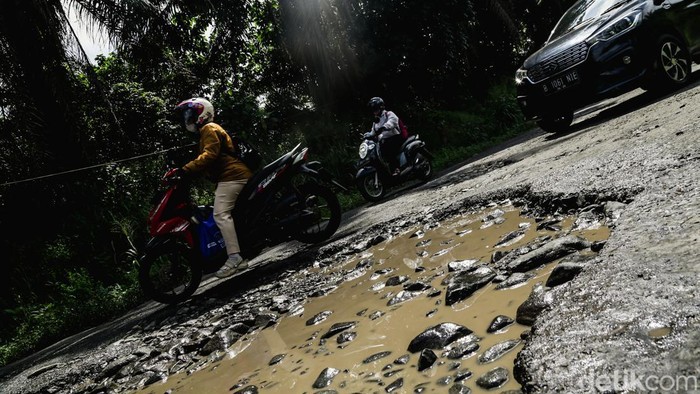 Pengendara melintas di Jalan Raya Serpong-Gunung Sindur, Bogor, Jumat (31/1/2025). Kondisi jalanan rusak dan berlubang.
