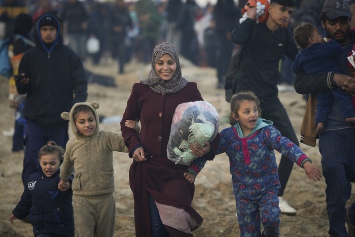 Carrying their belongings displaced Palestinians walk on a road to return to their homes in the northern Gaza Strip, Tuesday, Jan. 28, 2025, after Israels decision to allow thousands of them to go back for the first time since the early weeks of the 15-month war with Hamas. (AP Photo/Abdel Kareem Hana)