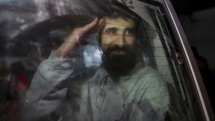Freed Palestinian prisoners wave from a bus as they arrive in the Gaza Strip after being released from an Israeli prison following a ceasefire agreement between Hamas and Israel in Khan Younis, Thursday, Jan. 30, 2025. (AP Photo/Jehad Alshrafi)