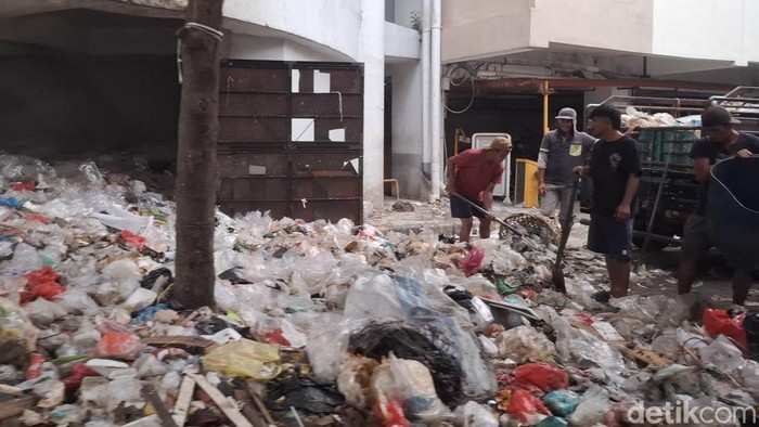 Pekerja saat mengangkut sampah di belakang Sukarami Trade Center (Raja Adil Siregar/detikSumut)