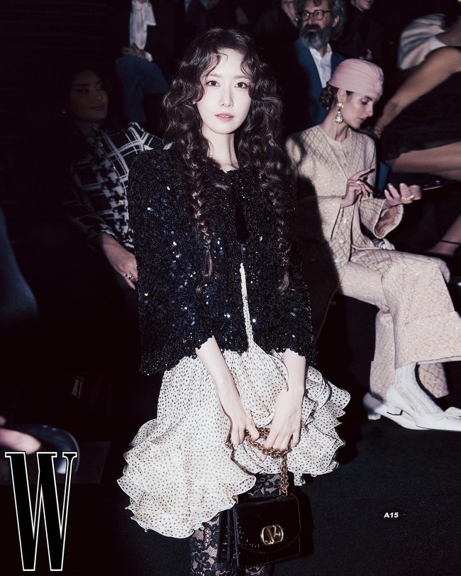 Yoona memakai sequin jacket hitam yang dipadukan dengan ruffle skirt krem bermotif polkadot dan lace tights bermotif floral. Bak boneka hidup, Yoona mencuri perhatian dengan rambutnya yang di-styling curly. Foto: dok. W Korea