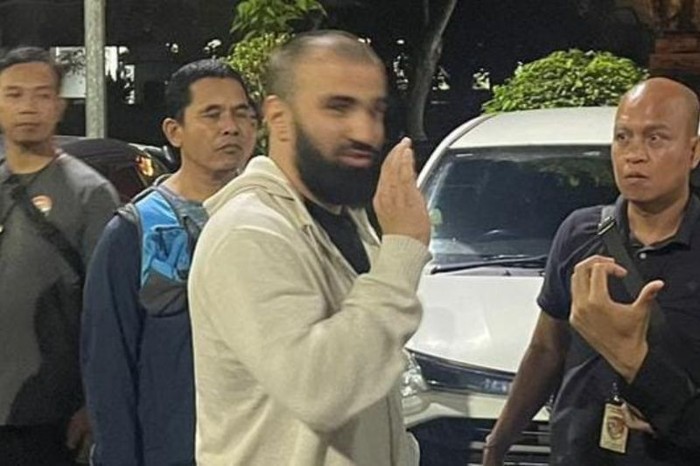 Polisi menggiring terduga pelaku perampokan berinisial KA saat ditangkap di Bandara Internasional I Gusti Ngurah Rai, Bali. (ANTARA/HO-Istimewa)