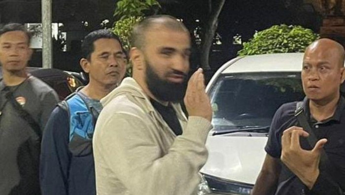 Polisi menggiring terduga pelaku perampokan berinisial KA saat ditangkap di Bandara Internasional I Gusti Ngurah Rai, Bali. (ANTARA/HO-Istimewa)