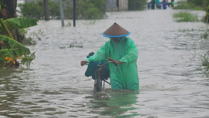 Warga mengangkut tabung gas elpiji dengan perahu untuk melintasi jalan yang tergenang banjir di Dukuh Karangturi, Desa Setrokalangan, Kaliwungu, Kudus, Jawa Tengah, Jumat (31/1/2025). Menurut warga setempat, akses jalan utama sepanjang sekitar satu kilometer tersebut terendam banjir akibat meluapnya Sungai Wulan sejak Kamis (23/1/2025), dan sebanyak seribuan warga dari 450 KK terisolasi sehingga harus menggunakan perahu hingga menerobos banjir untuk menjalankan aktivitas sehari-hari. ANTARA FOTO/Yusuf Nugroho/foc.