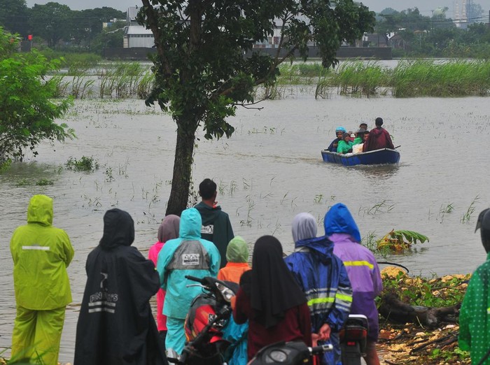 Warga mengangkut tabung gas elpiji dengan perahu untuk melintasi jalan yang tergenang banjir di Dukuh Karangturi, Desa Setrokalangan, Kaliwungu, Kudus, Jawa Tengah, Jumat (31/1/2025). Menurut warga setempat, akses jalan utama sepanjang sekitar satu kilometer tersebut terendam banjir akibat meluapnya Sungai Wulan sejak Kamis (23/1/2025), dan sebanyak seribuan warga dari 450 KK terisolasi sehingga harus menggunakan perahu hingga menerobos banjir untuk menjalankan aktivitas sehari-hari. ANTARA FOTO/Yusuf Nugroho/foc.