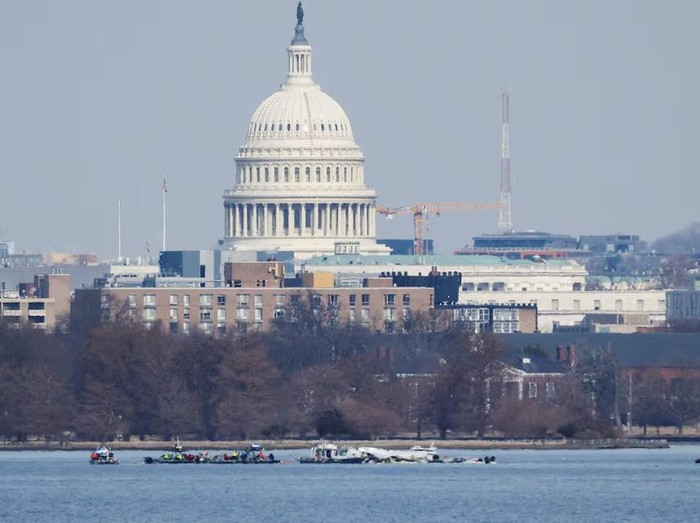 Search and rescue teams work in the aftermath of the collision of American Eagle flight 5342 and a Black Hawk helicopter that crashed into the Potomac River, with the Capitol dome in the background, as seen from Virginia, U.S., January 30, 2025. REUTERS/Carlos Barria Purchase Licensing Rights