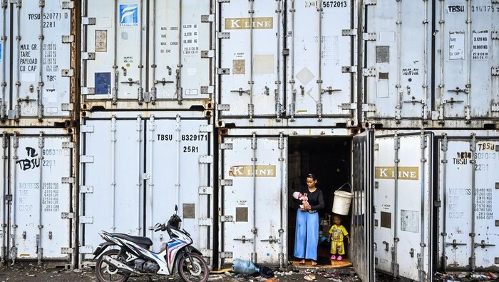 Warga Rorotan yang Terdampak Banjir Ngungsi di Kontainer Kosong Pengungsi menggendong anaknya di dalam kontainer kosong di Rorotan, Jakarta, Jumat (31/1/2025). Warga Kampung Sepatan, RT 18/05, Rorotan, Cilincing terpaksa mengungsi ke kontainer kosong setelah kediamannya terendam banjir setinggi satu meter. ANTARA FOTO/Rivan Awal Lingga/nz