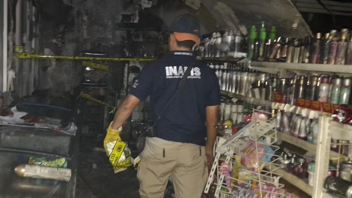Polisi saat mendatangi lokasi mini market yang terbakar di Bandar Lampung.