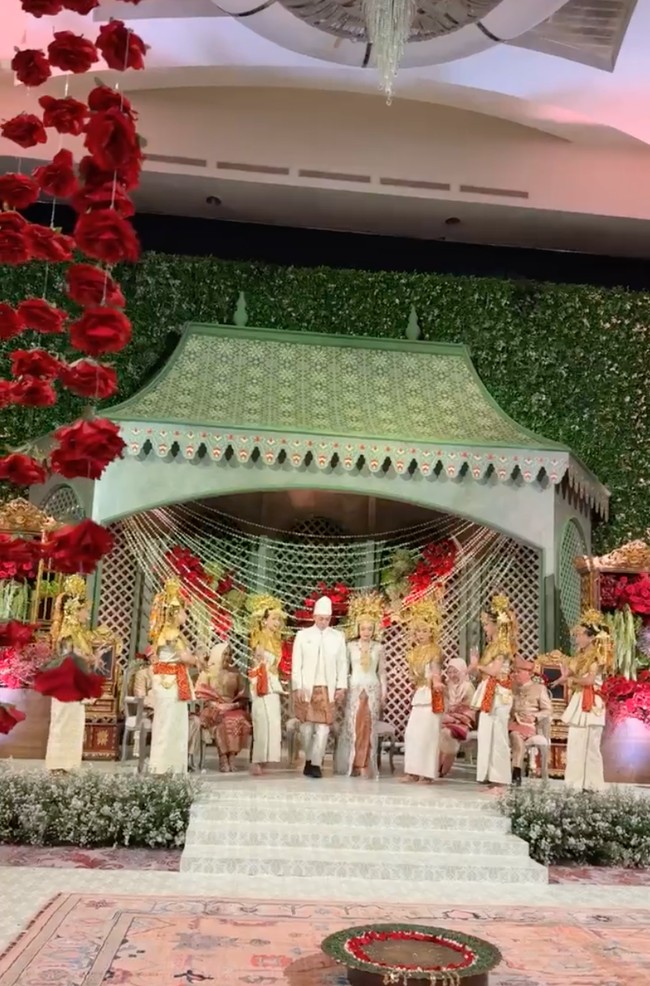 Tamara dan Rasyid tampil kompak mengenakan busana pengantin adat Palembang berwarna putih. Atasan berwarna putih dipadukan dengan kain songket Palembang berwarna merah keemasan. Penampilan Rasyid juga dilengkapi dengan penutup kepala khas pengantin pria adat Palembang. Sementara Tamara mengenakan headpiece khas wanita Palembang. Foto: Instagram/@ruby_26