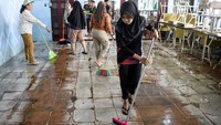 Lumpur yang mengotori lantai dibersihkan. 