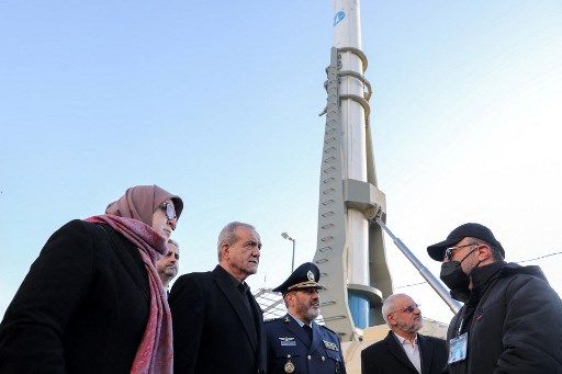 In this handout picture provided by the Iranian presidency on February 2, 2025, President Masoud Pezeshkian (C) visits a defence and space achievements exhibition in Tehran. Iran on February 2 revealed a new ballistic missile with an official range of 1,700 kilometres, in a Tehran ceremony attended by President Masoud Pezeshkian. (Photo by Iranian Presidency / AFP) / === RESTRICTED TO EDITORIAL USE - MANDATORY CREDIT 