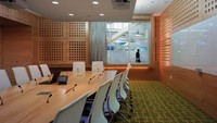 Seperti kantor pada umumnya, ada ruang kantor dengan meja panjang. Ruangan ini didominasi elemen kayu dan dipadukan dengan karpet berwarna hijau.