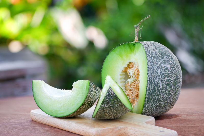 Fresh melon sliced Place on a wooden cutting board on a wooden table with beautiful natural blurred background.