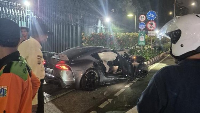 Mobil jenis sedan Toyota Supra menabrak tiang lampu hingga roboh di dekat Bundaran HI. Nahas, tiang lampu itu lalu menimpa pengendara motor yang melintas. (dok Pribadi/D Haikal)