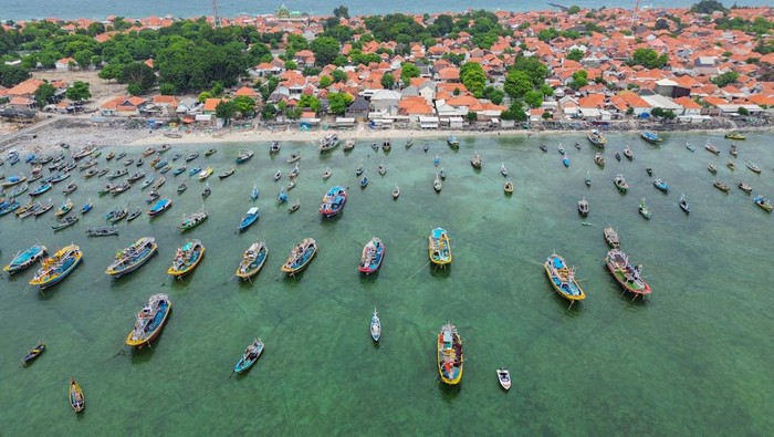 Nelayan memperbaiki jala ikan saat tak melaut di pesisir selata Pulau Gili Ketapang, Kabupaten Probolinggo, Jawa Timur, Senin (3/2/2025). Sejumlah nelayan di kawasan tersebut memilih tidak melaut sejak 15 hari terakhir dikarenakan cuaca buruk, gelombang tinggi dan angin kencang di perairan Laut Jawa. ANTARA FOTO/Irfan Sumanjaya/Spt.