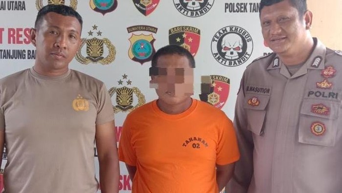 Pelaku Dandi (tengah) saat diamankan petugas kepolisian. (Dok. Polsek Tanjungbalai Utara)