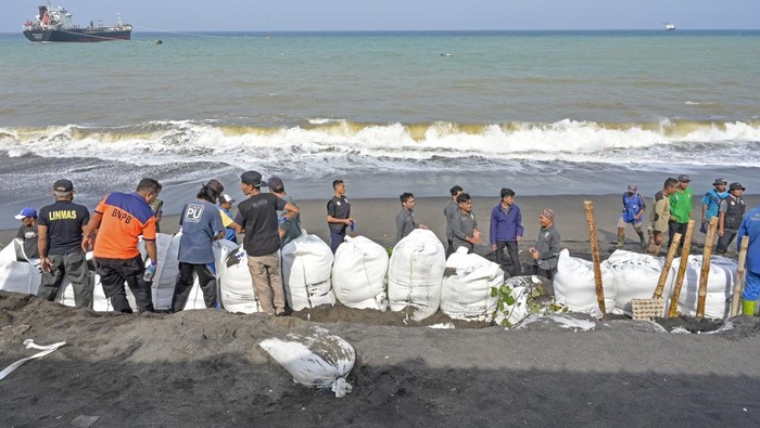Pembuatan tanggul penahan ombak di Ampenan Operator menggunakan alat berat membuat tanggul penahan ombak di samping jalan yang rusak akibat diterjang gelombang tinggi di Lingkungan Bugis, Ampenan, Mataram, NTB, Senin (3/2/2025). Gelombang tinggi dan pasang yang terjadi sejak dua hari lalu tersebut mengakibatkan jalan rusak serta sejumlah rumah warga roboh akibat abrasi pantai. ANTARA FOTO/Ahmad Subaidi/Spt.
