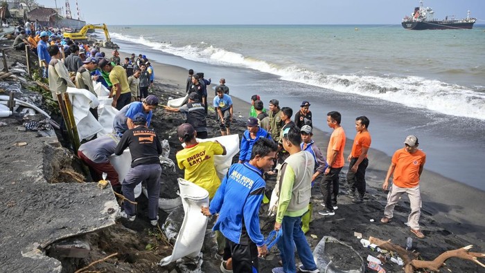 Operator menggunakan alat berat membuat tanggul penahan ombak di samping jalan yang rusak akibat diterjang gelombang tinggi di Lingkungan Bugis, Ampenan, Mataram, NTB, Senin (3/2/2025). Gelombang tinggi dan pasang yang terjadi sejak dua hari lalu tersebut mengakibatkan jalan rusak serta sejumlah rumah warga roboh akibat abrasi pantai. ANTARA FOTO/Ahmad Subaidi/Spt.