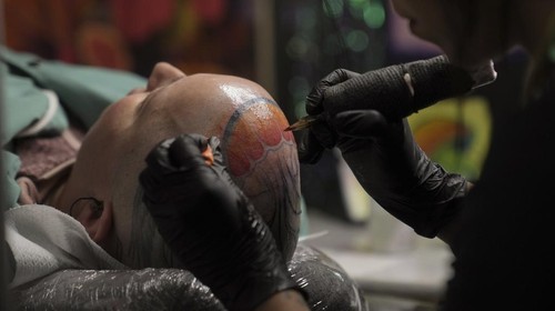 A man with a tattoo on his chest takes part in a contest during a tattoo convention, in Paris, Sunday, Feb. 2, 2025. (AP Photo/Thibault Camus)