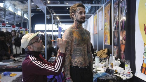 A man with a tattoo on his chest takes part in a contest during a tattoo convention, in Paris, Sunday, Feb. 2, 2025. (AP Photo/Thibault Camus)