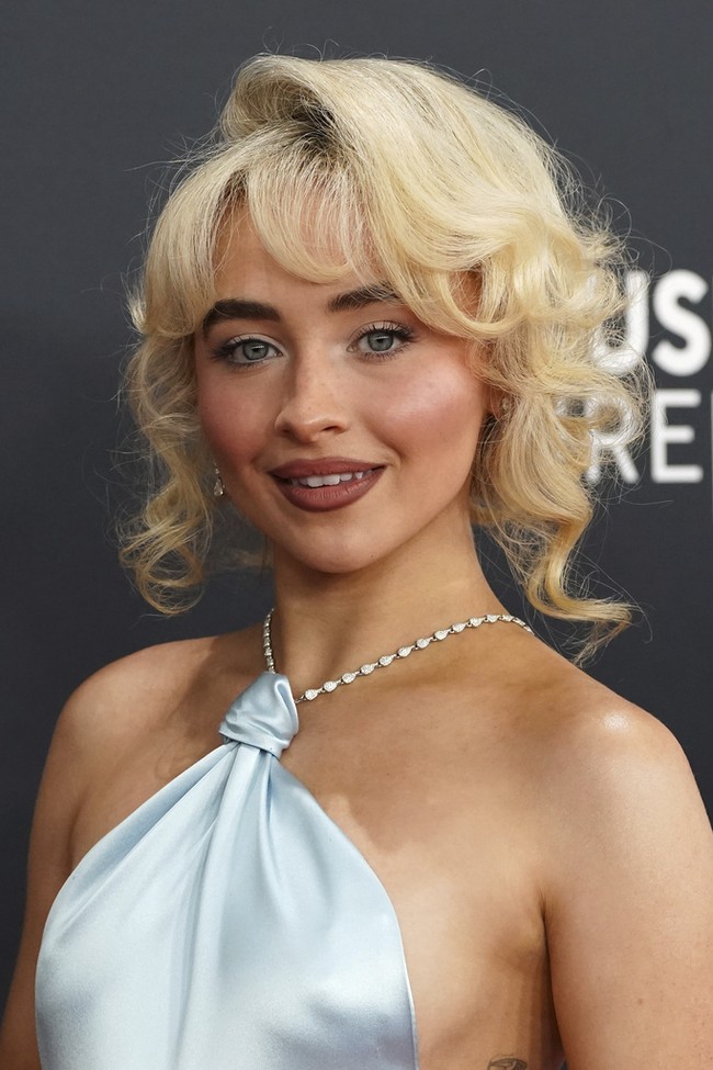 Sabrina CarpenterPenyanyi ‘Espresso’ ini tetap mempertahankan estetika retro-glamnya dengan updo curly pinned, alis tegas, dan bibir berkontur. Penata rambut Evanie Frausto menggunakan L’Oréal Professionnel AirLight Pro serta produk dari Redken untuk menciptakan tampilan rambut ala Prancis. Sementara itu, makeup artist Carolina Gonzalez mempersiapkan kulit Sabrina Carpenter dengan skincare dari SK-II sebelum mengaplikasikan makeup dari Prada Beauty. Foto: Jordan Strauss/Invision/AP