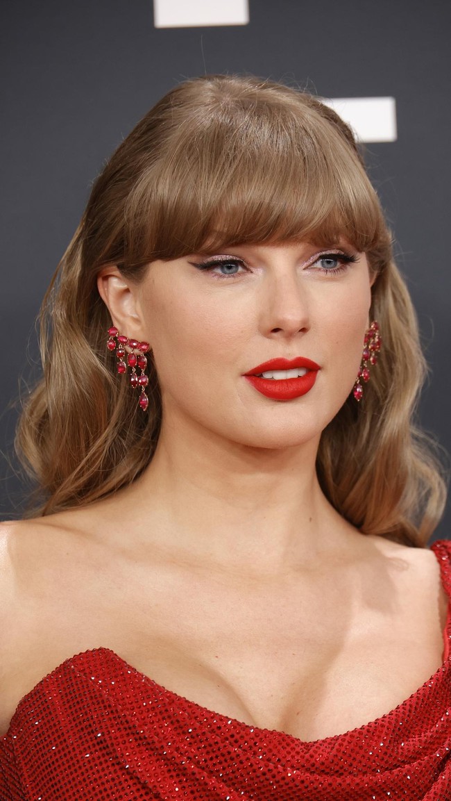 Taylor SwiftRiasan ikonik Taylor Swift tetap menjadi favorit. Eyeliner winged hitam dan lipstik merah terang berpadu sempurna dengan gaya rambut retro yang ditata dengan sempurna. Foto: Getty Images for The Recording A/Kevin Winter