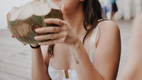 Kekasih Rangga Azof ini juga sering mengunggah momen liburannya. Begini momennya di Bali saat menikmati kelapa muda di pantai. Foto: Instagram