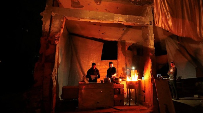 Malam-malam Hari di Gaza Palestinians warm themselves by a fire, during a power cut, amid a ceasefire between Israel and Hamas, in Gaza City, February 3, 2025. REUTERS/Dawoud Abu Alkas