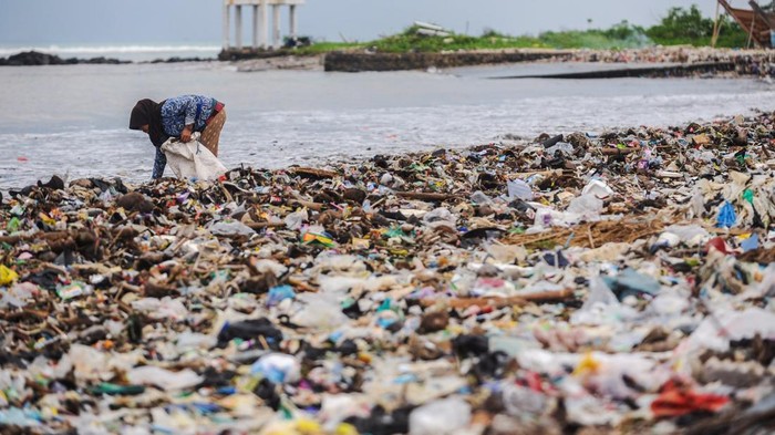 Warga melintas di sekitar tumpukan sampah di Pantai Teluk Labuan, Pandeglang, Banten, Selasa (4/1/2025). Tumpukan sampah yang sebelumnya telah dibersihkan pegiat lingkungan bersama pemerintah tersebut kini menumpuk kembali, selain akibat terbawa gelombang tinggi, juga disebabkan minimnya kesadaran warga dalam membuang sampah. ANTARA FOTO/Muhammad Bagus Khoirunas/Spt.