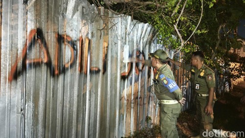 Satpol PP Kota Solo saat menghapus vandalisme bertuliskan Adili Jokowi di Jalan Prof. Soeharso, Kecamatan Laweyan, Kota Solo, Selasa (4/2/2025).