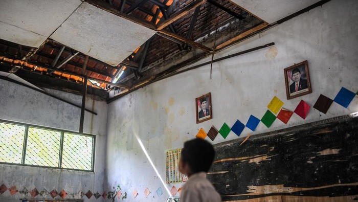 Siswa kelas 1 mengikuti kegiatan belajar mengajar di luar ruangan SD Negeri Pasirtenjo 4, Pandeglang, Banten, Selasa (4/2/2025). Menurut pihak sekolah, sebanyak enam ruang kelas satu mengalami kerusakan dan satu di antaranya rusak parah dengan kondisi atap roboh sehingga menyebabkan kegiatan belajar mengajar terpaksa dilaksanakan di luar ruangan dan hingga kini belum mendapatkan perhatian dari Pemerintah Kabupaten Pandeglang. ANTARA FOTO/Muhammad Bagus Khoirunas/tom.