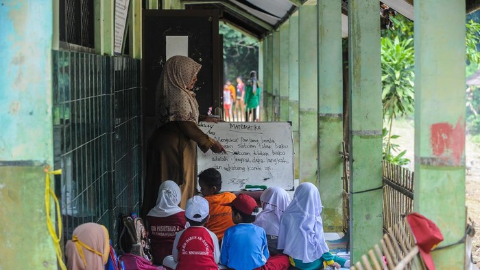 Siswa kelas 1 mengikuti kegiatan belajar mengajar di luar ruangan SD Negeri Pasirtenjo 4, Pandeglang, Banten, Selasa (4/2/2025). Menurut pihak sekolah, sebanyak enam ruang kelas satu mengalami kerusakan dan satu di antaranya rusak parah dengan kondisi atap roboh sehingga menyebabkan kegiatan belajar mengajar terpaksa dilaksanakan di luar ruangan dan hingga kini belum mendapatkan perhatian dari Pemerintah Kabupaten Pandeglang. ANTARA FOTO/Muhammad Bagus Khoirunas/tom.