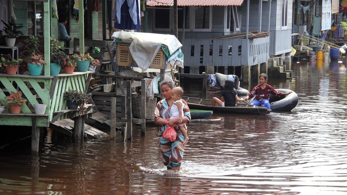 Warga melintasi banjir di Kecamatan Tanah Putih Rokan Hilir, Riau, Selasa (4/2/2025). Pemukiman warga di daerah tersebut dilanda banjir sejak sepekan lalu akibat luapan air sungai yang berasal dari banjir di Rokan Hulu Riau. ANTARA FOTO/Aswaddy Hamid/Spt.