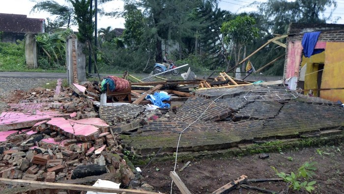 Warga melintas di samping rumah yang ambruk akibat diterjang angin puting beliung di Kelurahan Langkapura, Bandar Lampung, Lampung, Rabu (5/2/2025). Angin puting beliung yang terjadi pada Selasa (4/2/2025) tersebut mengakibatkan 30 rumah di Kelurahan tersebut mengalami kerusakan. ANTARA FOTO/Ardiansyah/nym.