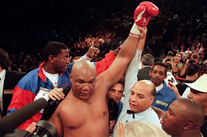 Referee Joe Cortez (R) holds George Foremans arm up in victory after Foreman knocked Michael Moorer out in the tenth round of their scheduled 12 round IBF/WBA heavyweight title fight, on November 05, 1994 in Las Vegas, Nevada. Foreman became the oldest fighter to win a championship in any weight class. (Photo by JOHN GURZINSKI / AFP)
