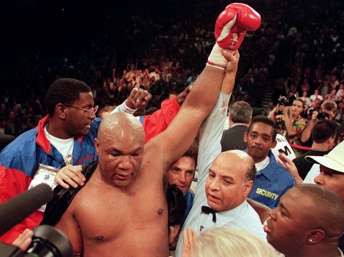 Referee Joe Cortez (R) holds George Foremans arm up in victory after Foreman knocked Michael Moorer out in the tenth round of their scheduled 12 round IBF/WBA heavyweight title fight, on November 05, 1994 in Las Vegas, Nevada. Foreman became the oldest fighter to win a championship in any weight class. (Photo by JOHN GURZINSKI / AFP)