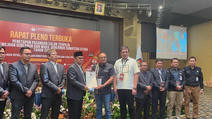 Ketua KPU Sumut Agus Arifin saat menyerahkan salinan putusan rapat pleno terbuka ke tim pemenangan Bobby-Surya. (Finta Rahyuni/detikSumut)