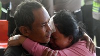 Korban luka-luka Sugiarti (kanan) menangis di pelukan anggota keluarganya.  