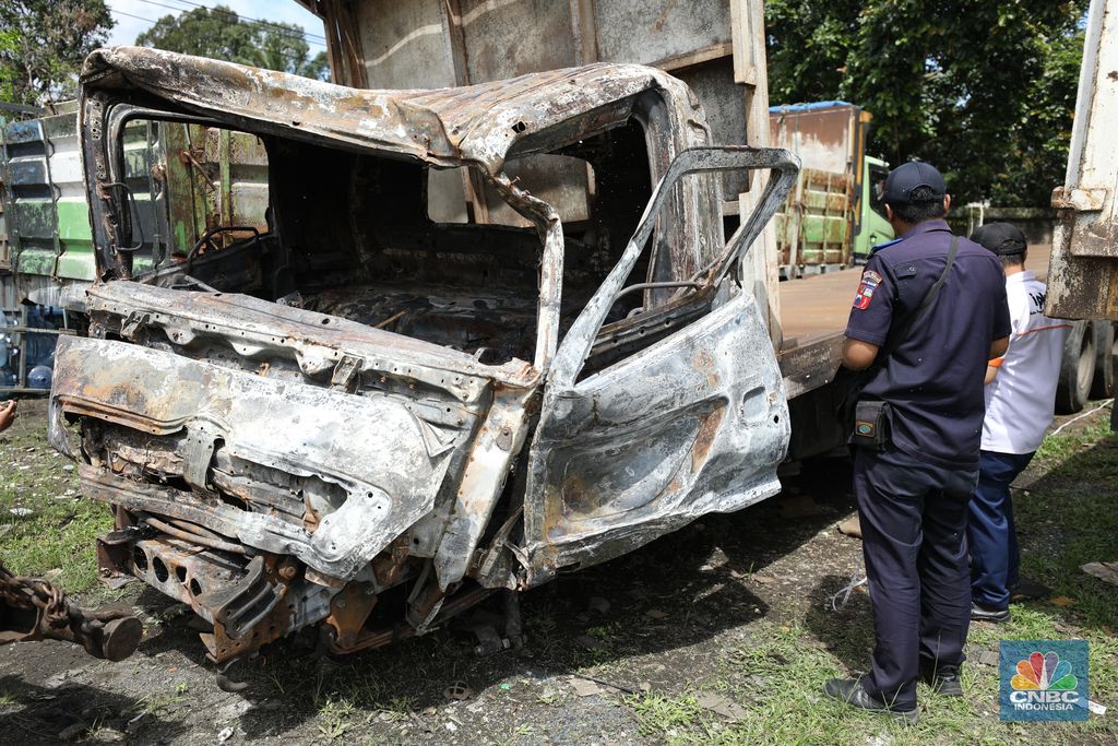 Petugas memeriksa bangkai kendaraan yang terbakar dalam kecelakaan di Gerbang Tol Ciawi kini berada di Kantor PJR Ciawi, Rabu (5/2/2025). (CNBC Indonesia/Tri Susilo)