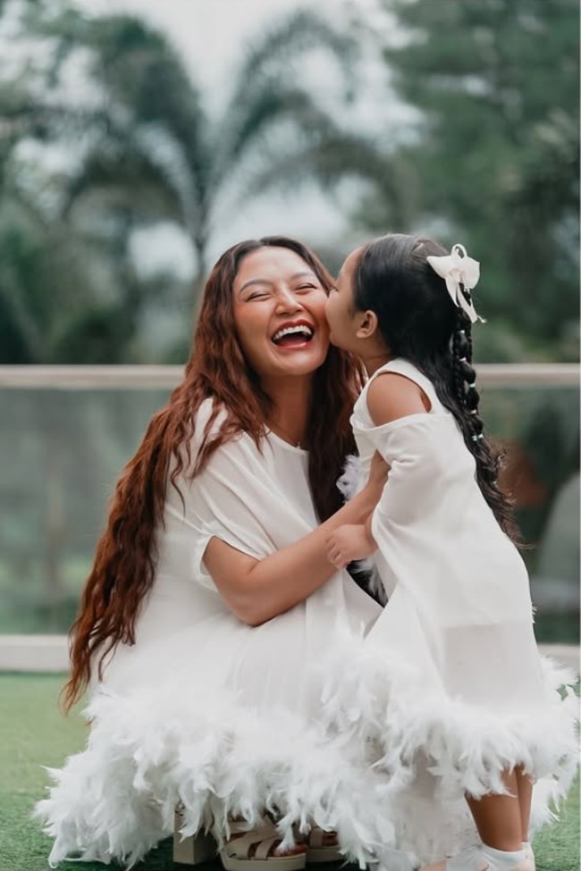 Siti dan Xarena memilih kenakan dress kembar. Bagian bawah dress tersebut tampak dipercantik dengan rumbai bulu warna senada. Foto: Instagram/@sitibadriahh