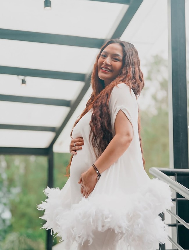Baby bump di perut Siti juga terlihat sudah semakin besar. Dengan rambut panjang bergayaa mermaid curl yang dibiarkan terurai serta riasan wajah natural, penampilan Siti terlihat simpel. Foto: Instagram/@sitibadriahh