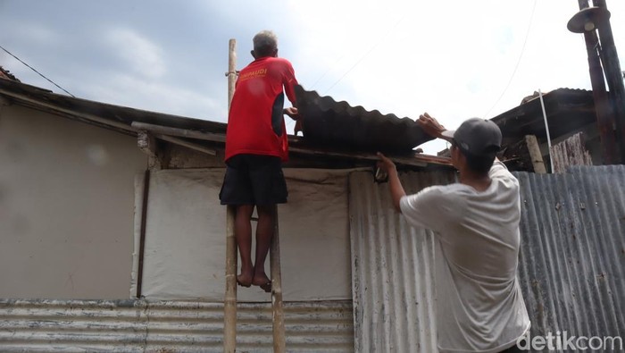 Warga secara swadaya membetulkan atap rumahnya yang porak poranda usai diterjang angin puting beliung di Kelurahan Kranji, Kecamatan Purwokerto Timur, Kabupaten Banyumas, Rabu (5/2/2025).