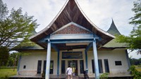 Warga berjalan di depan kantor Bandara Pusako Anak Nagari yang sudah tidak beroperasi di Pasaman Barat, Sumatera Barat.